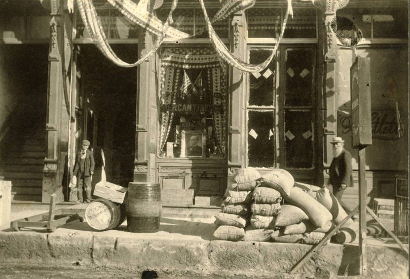 Historic storefront of the Port Townsend Mercantile Company with sacks, barrels, and goods displayed outside.
