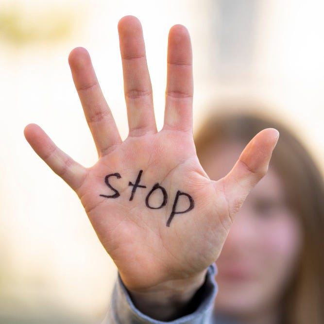 Hand out in stop gester with "stop" written on the palm