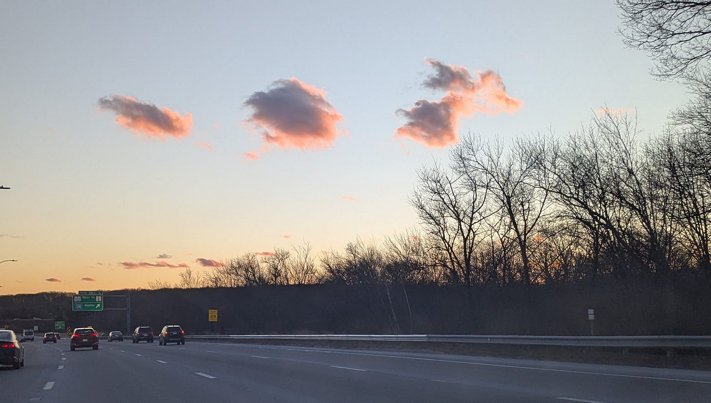 Late winter sky with three pink clouds.