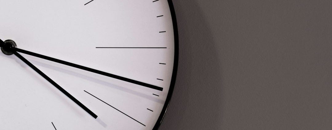 white analog wall clock at 11 00