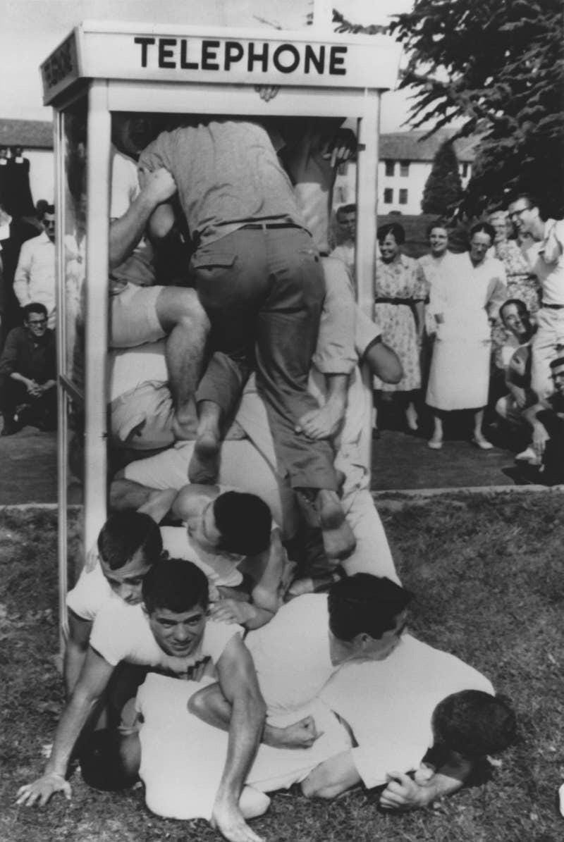 Capturing a popular 1950s fad: a crowded phone booth, as people attempted 'phonebooth stuffing,' with a record of 25 individuals. Capturing a popular 1950s fad: a crowded phone booth, as people attempted 'phonebooth stuffing,' with a record of 25 individuals.