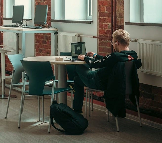 a person sitting at a table with a laptop