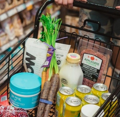 a person pushing a shopping cart full of food