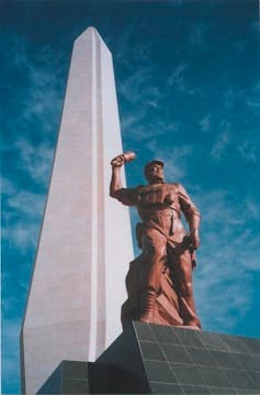 Statue shows a man carrying a touch in his right hand