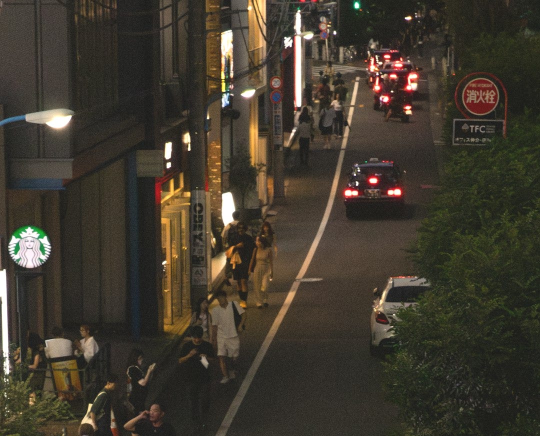 A night street scene with cars and people. A night street scene with cars and people.