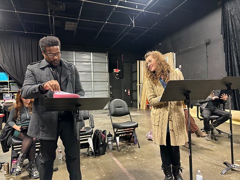 Actors reading a play in a theater.