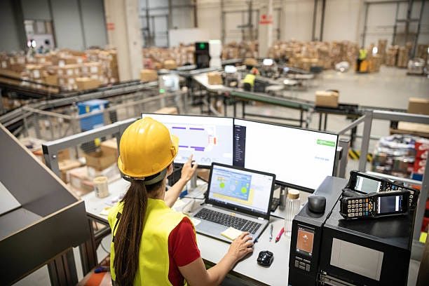 Woman Analyzing Warehouse Data on Computer A woman is analyzing real-time data on her computer within a warehouse, demonstrating tech integration in logistics. warehouse stock pictures, royalty-free photos & images Woman Analyzing Warehouse Data on Computer A woman is analyzing real-time data on her computer within a warehouse, demonstrating tech integration in logistics. warehouse stock pictures, royalty-free photos & images