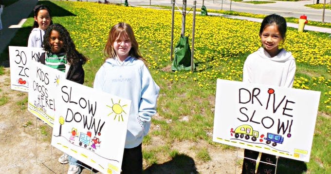 (From left to right) Danielle, Aluna, Lotti and Emily stood next to signs featuring their artwork in Kitchener, Ont. on May 11, 2026. (Dave Pettitt/CTV News)