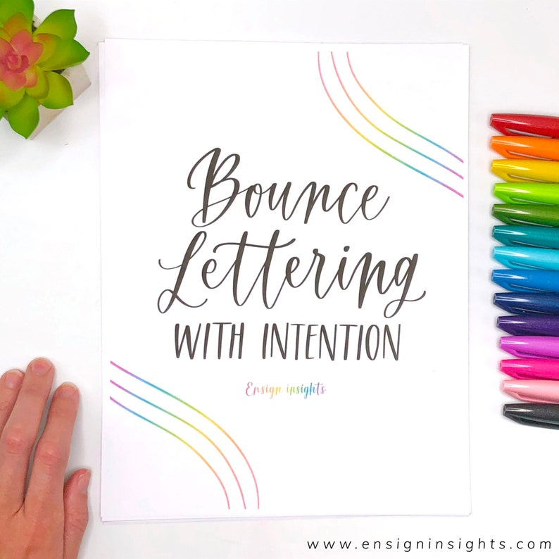 May include: A white sheet of paper with the text "Bounce Lettering with Intention" and a rainbow arc design. The text "Ensign Insights" is also visible at the bottom of the page. The website address "www.ensigninsights.com" is printed at the bottom of the page.
