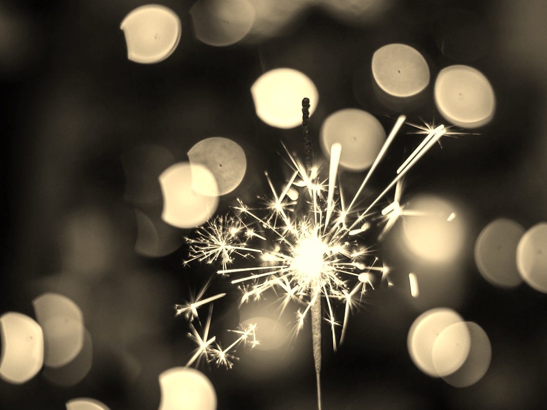 bokeh photography of person holding fireworks