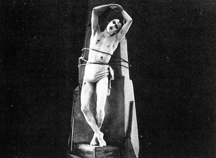 This may contain: a black and white photo of a man on a cross with his hands in the air