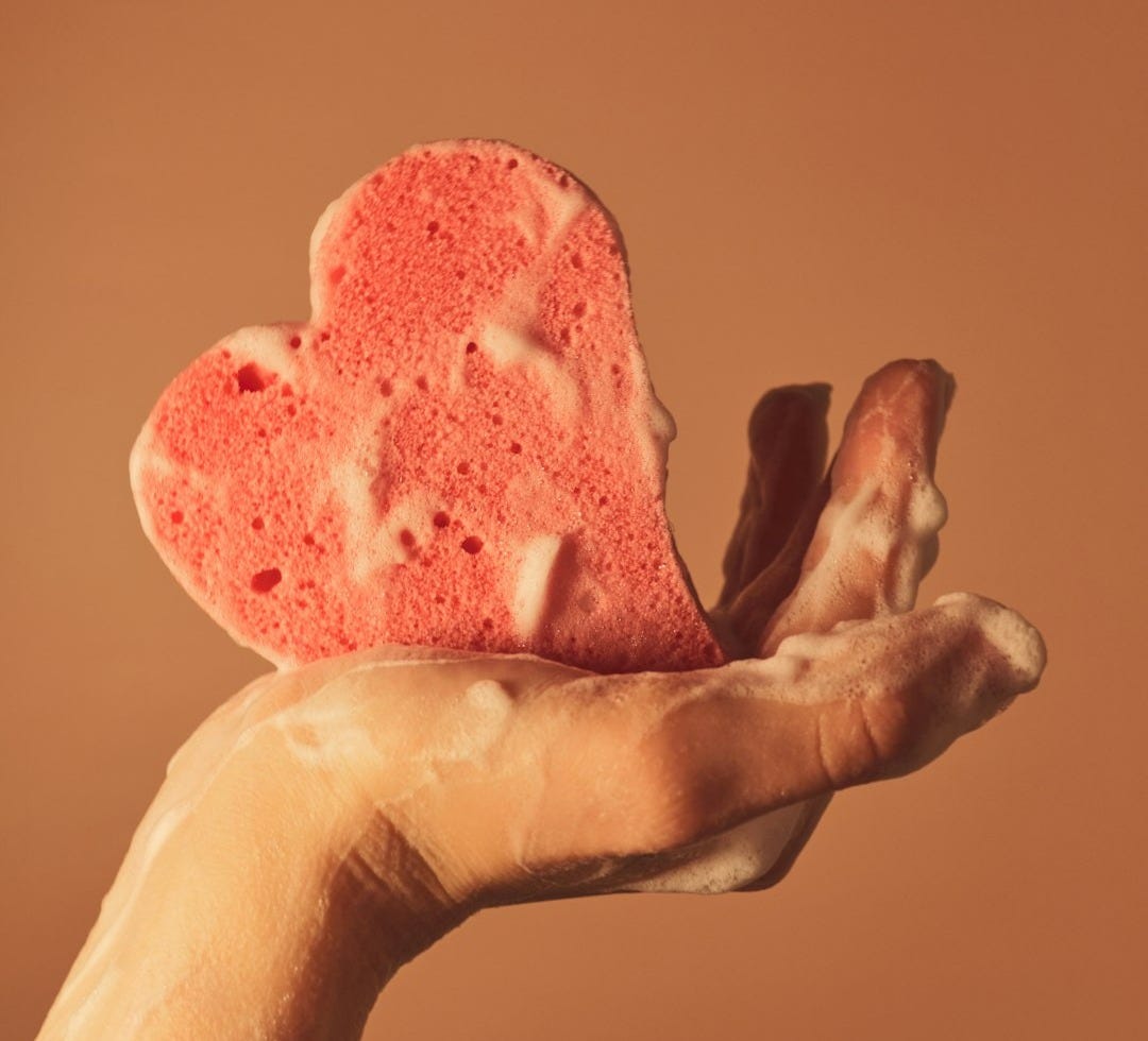 person holding pink heart shaped ornament