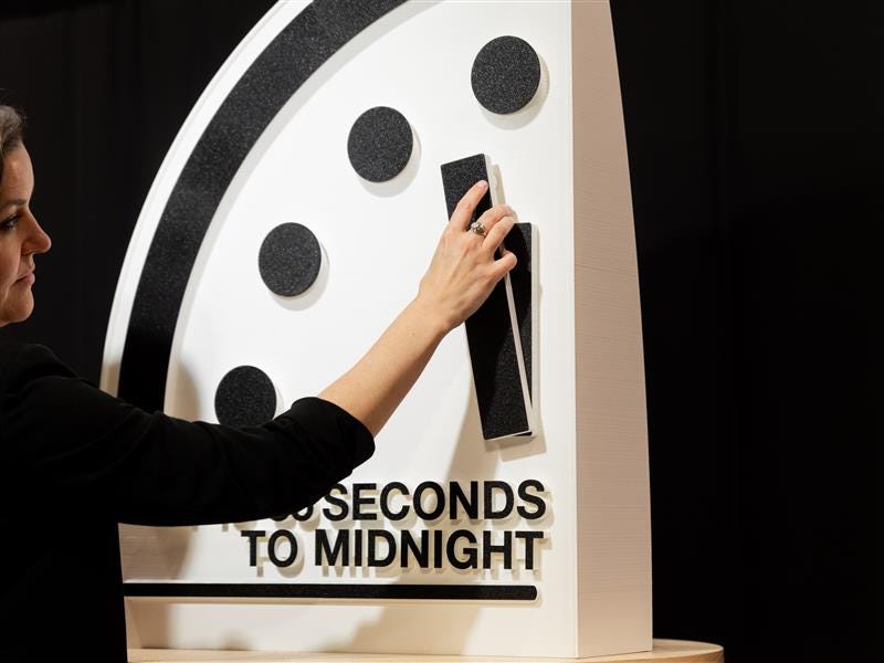 Alexandra Bell, president and CEO of the Bulletin of the Atomic Scientists adjusts the hands of the Doomsday Clock. Credit: Jamie Christiani