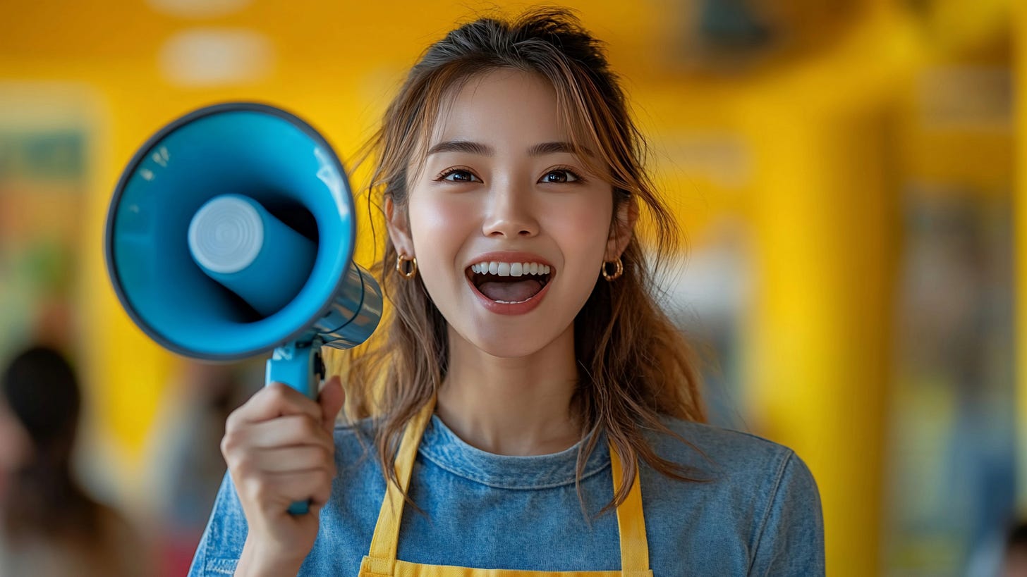 A smiling woman holds a blue megaphone in her hand. A smiling woman holds a blue megaphone in her hand.
