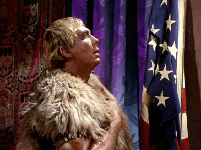 Screenshot of Yang leader Cloud William saluting tattered US flag in Star Trek TOS episode 'The Omega Glory'