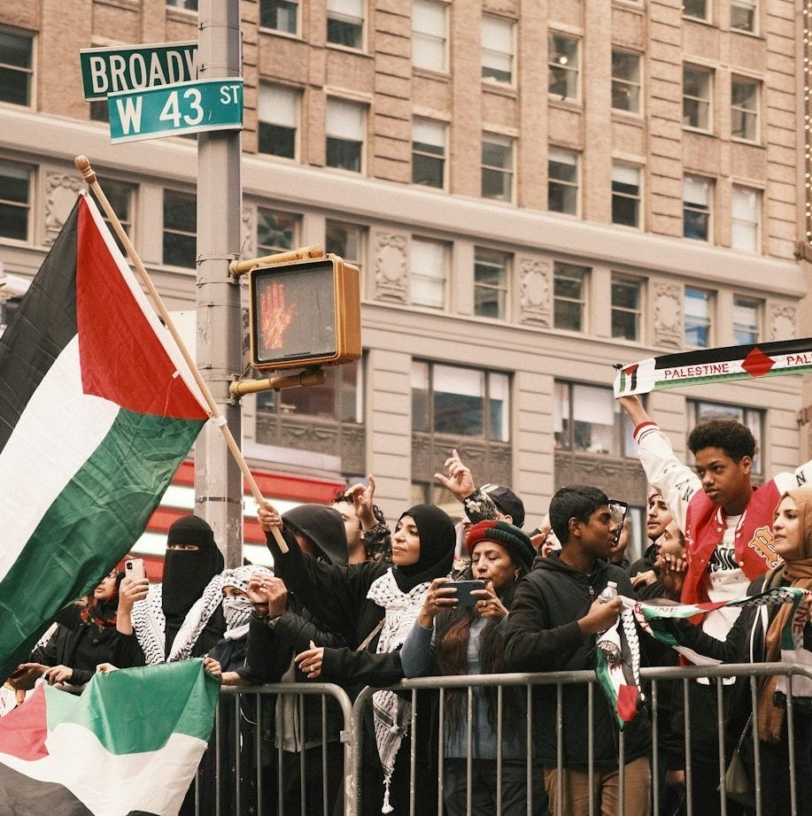 a crowd of people standing next to a metal barricade