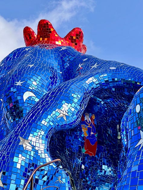 Three photos: A blue wall with a mosaic portrait of a woman with red hair, crying, the shiny blue and star tiled hair of the Empress. She has a red crown as well. The inside of the High Priestess. An open room tiled and painted blue. A hooded figure stands in the background.