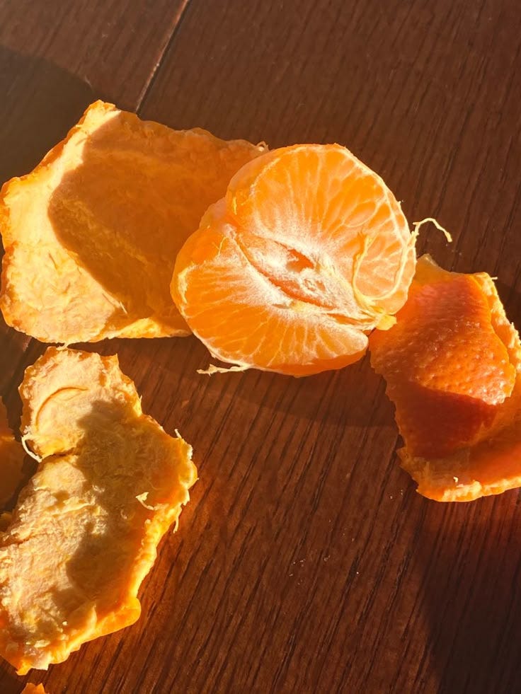 This may contain: peeled oranges sitting on top of a wooden table