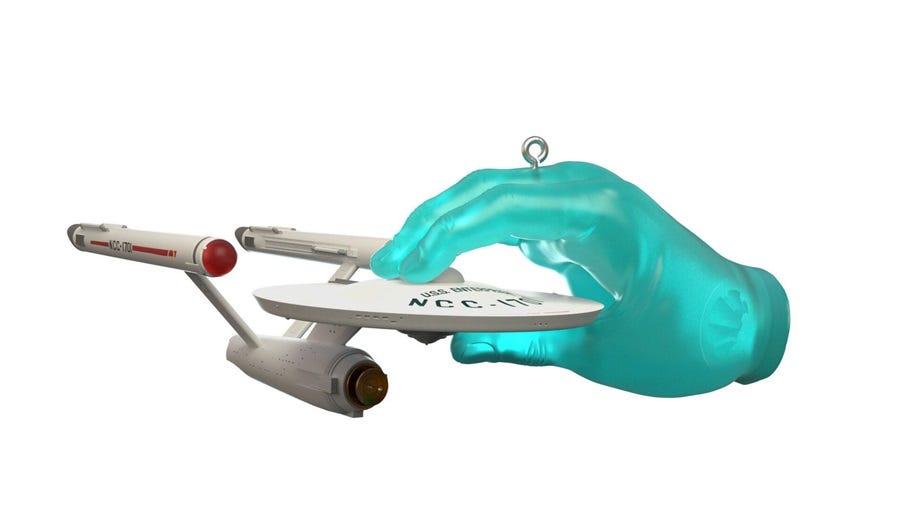 Photo of Christmas ornament depicting the starship Enterprise gripped by a giant green hand Photo of Christmas ornament depicting the starship Enterprise gripped by a giant green hand