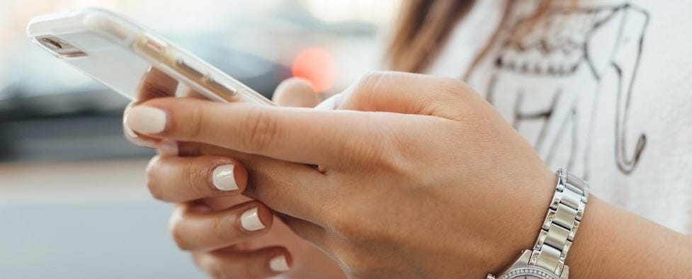 woman holding iPhone during daytime