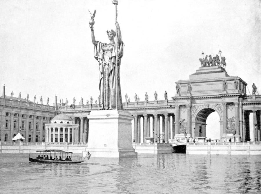 Passengers ride in a small boat past a tall statue on a pedestal in a basin surrounded by many-columned structures.