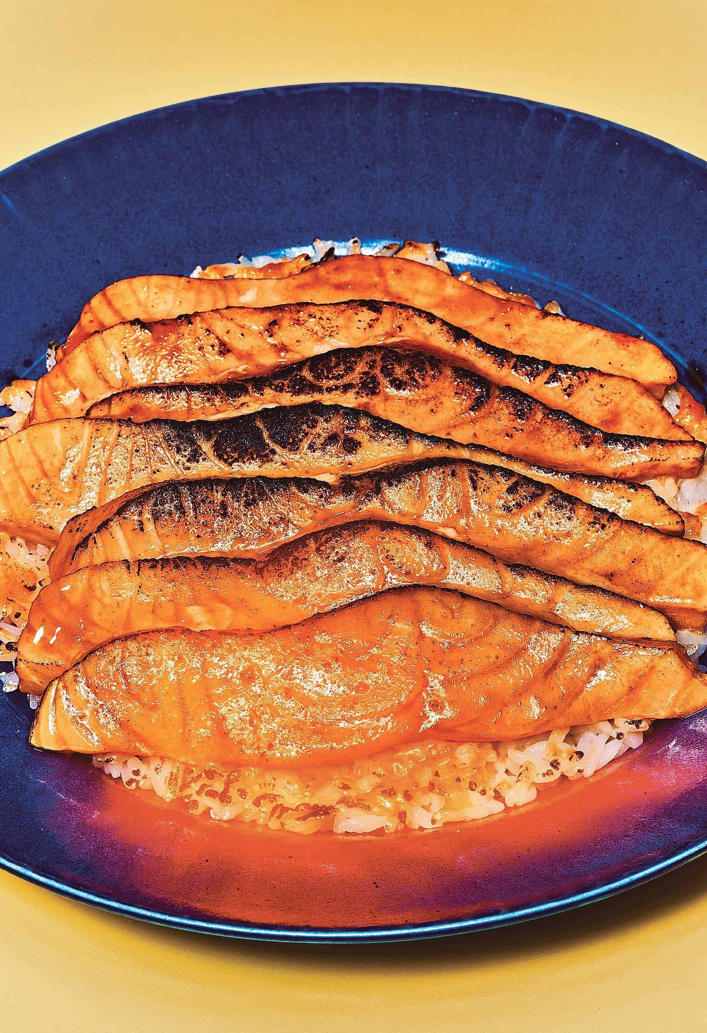 Torched salmon on a blue plate.