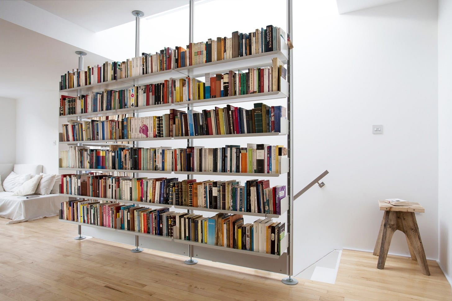 Floor to ceiling bookshelf. Hallway. Strong shelves for large collection of books. Modular 606 Shelving System. Designer, Dieter Rams. Vitsœ