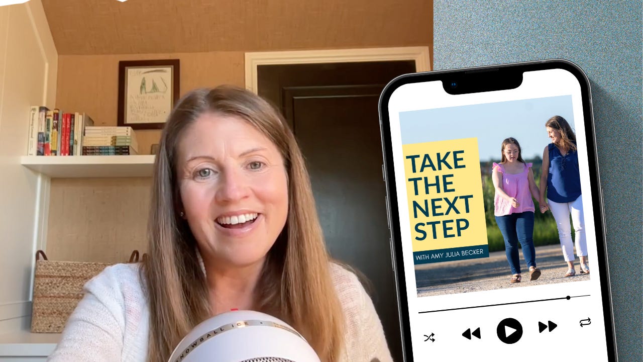 Amy Julia smiles while speaking into a white Snowball microphone, seated in a home office with bookshelves behind her. Next to her is an image of a smartphone screen displaying the cover of the podcast Take the Next Step with Amy Julia Becker, showing Amy Julia walking outdoors holding hands with her daughter, who has Down syndrome.
