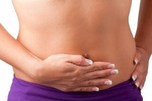 a thin woman holding her stomach with a stomach ache