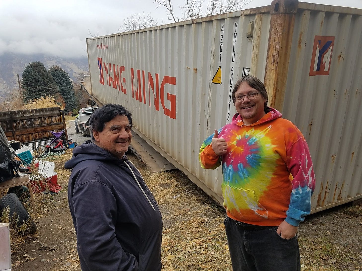 John Fenley and his father pose in front of a freight container John Fenley and his father pose in front of a freight container