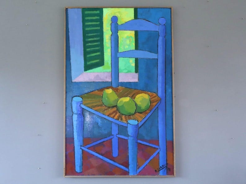 May include: A framed painting depicts a blue chair with three green fruits on its seat. The background features a window with green shutters and a blue wall. The painting has a colorful, abstract style.