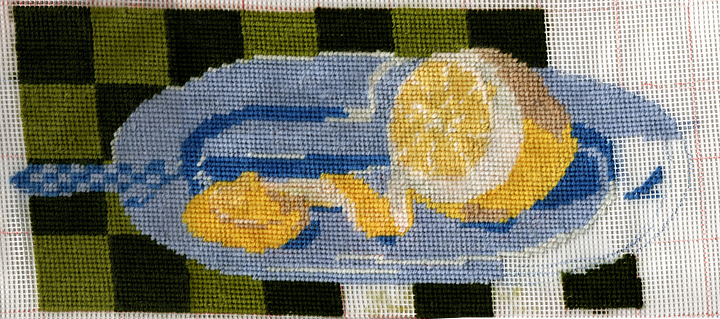 First image is a photo of myself in a lime green vest. Second is a needlepoint of a lemon on a plate. the tip has been cut off. the resulting tip looks like a nipple