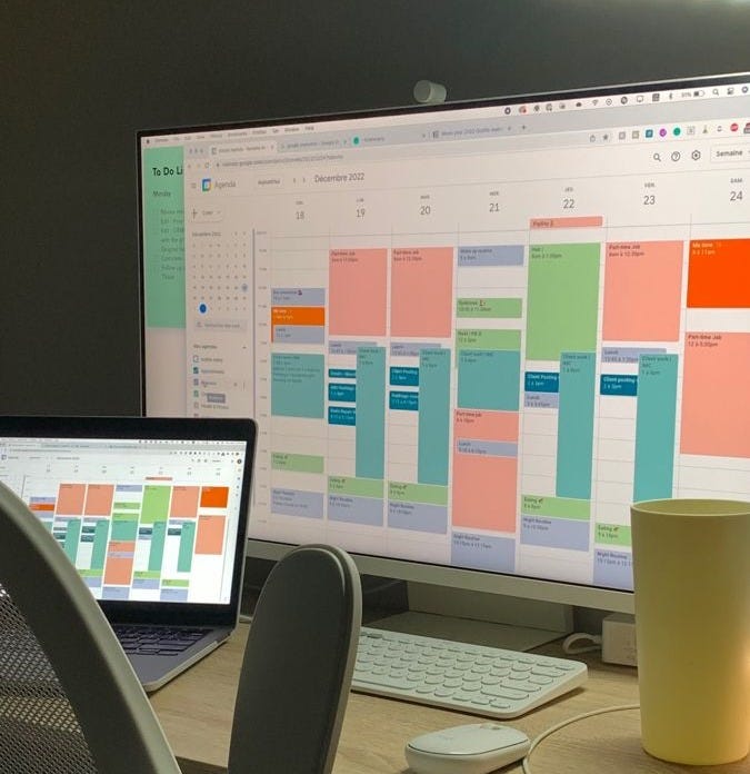 This may contain: an office desk with two computer monitors and a cup on it, in front of the monitor