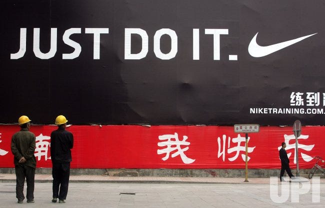 Photo: People walk past a Nike billboard in Beijing - PEK2008042808 -  UPI.com