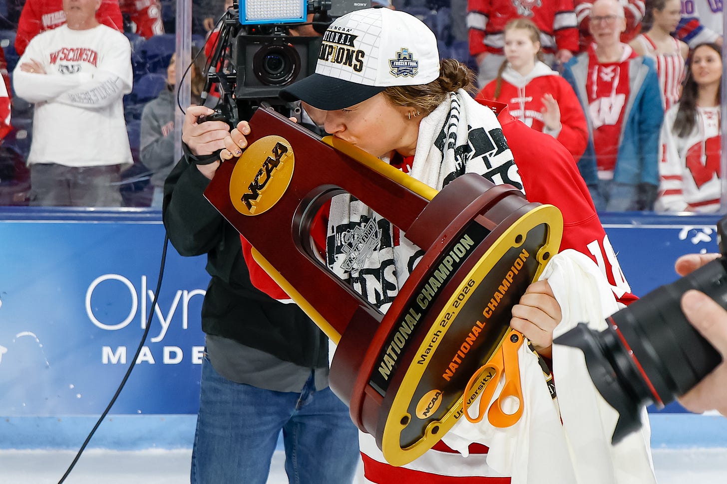 Marianne Picard kisses the NCAA national championship trophy in an on-ice celebration