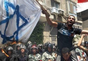 Egyptian demonstrators burn an Israeli flag during a protest outside the Israeli embassy in Cairo yesterday. Photo: AFP