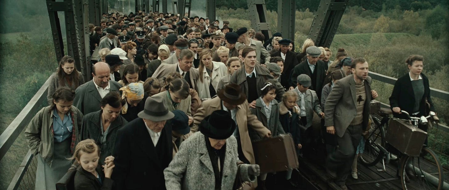 On a bridge in mid-September 1939, a crowd of people fleeing the Nazi invasion from the west of Poland is confronted by another crowd of people fleeing the Soviet invasion from the east. On a bridge in mid-September 1939, a crowd of people fleeing the Nazi invasion from the west of Poland is confronted by another crowd of people fleeing the Soviet invasion from the east.
