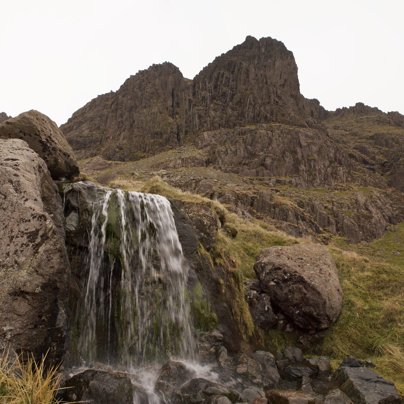 foreground waterfall, big rocky crag above