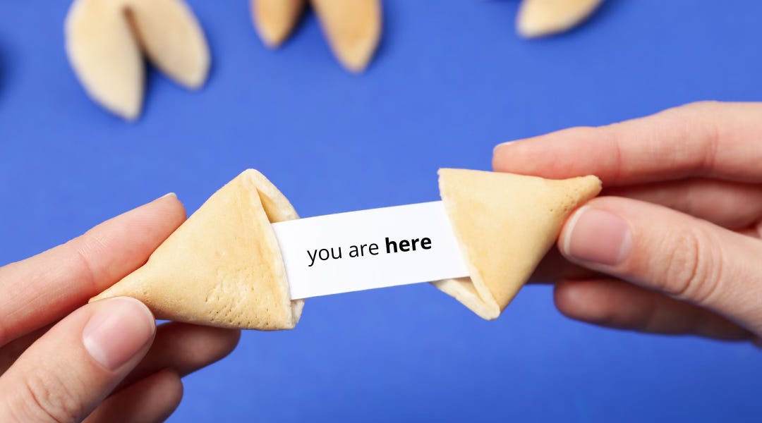 Image shows hands opening a fortune cookie. The text inside the fortune cookie reads 'you are here'.  Image shows hands opening a fortune cookie. The text inside the fortune cookie reads 'you are here'.