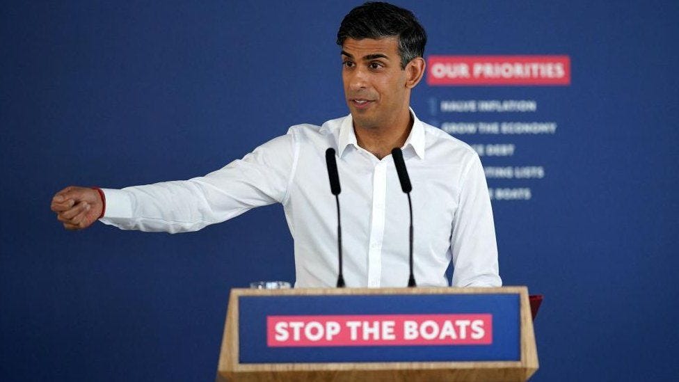 Rishi Sunak at a podium which reads "Stop the boats"