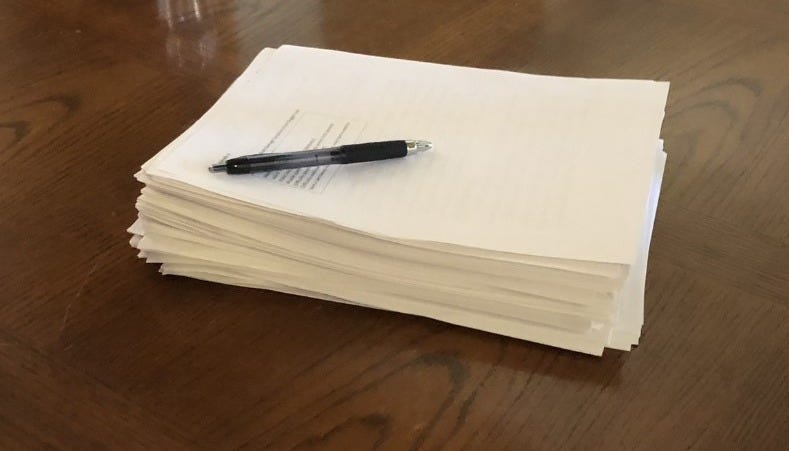 Manuscript in a pile with a pen lying across the top Manuscript in a pile with a pen lying across the top