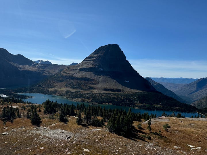 Four images, top left fighter jet flys over Columbia River Gorge. Top right: Hidden Lake with mountain in background and pine trees in foreground. Bottom left, river surrounded by rocks and pine trees, mountain in the background. Bottom right, pine trees in foreground with a river and train tracks snaking their way through the middle. Mountain range in the distance.