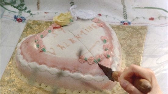 This may contain: someone is cutting into a heart shaped cake