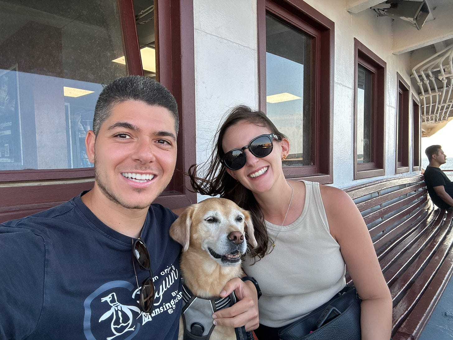 two humans and a dog on a ferry