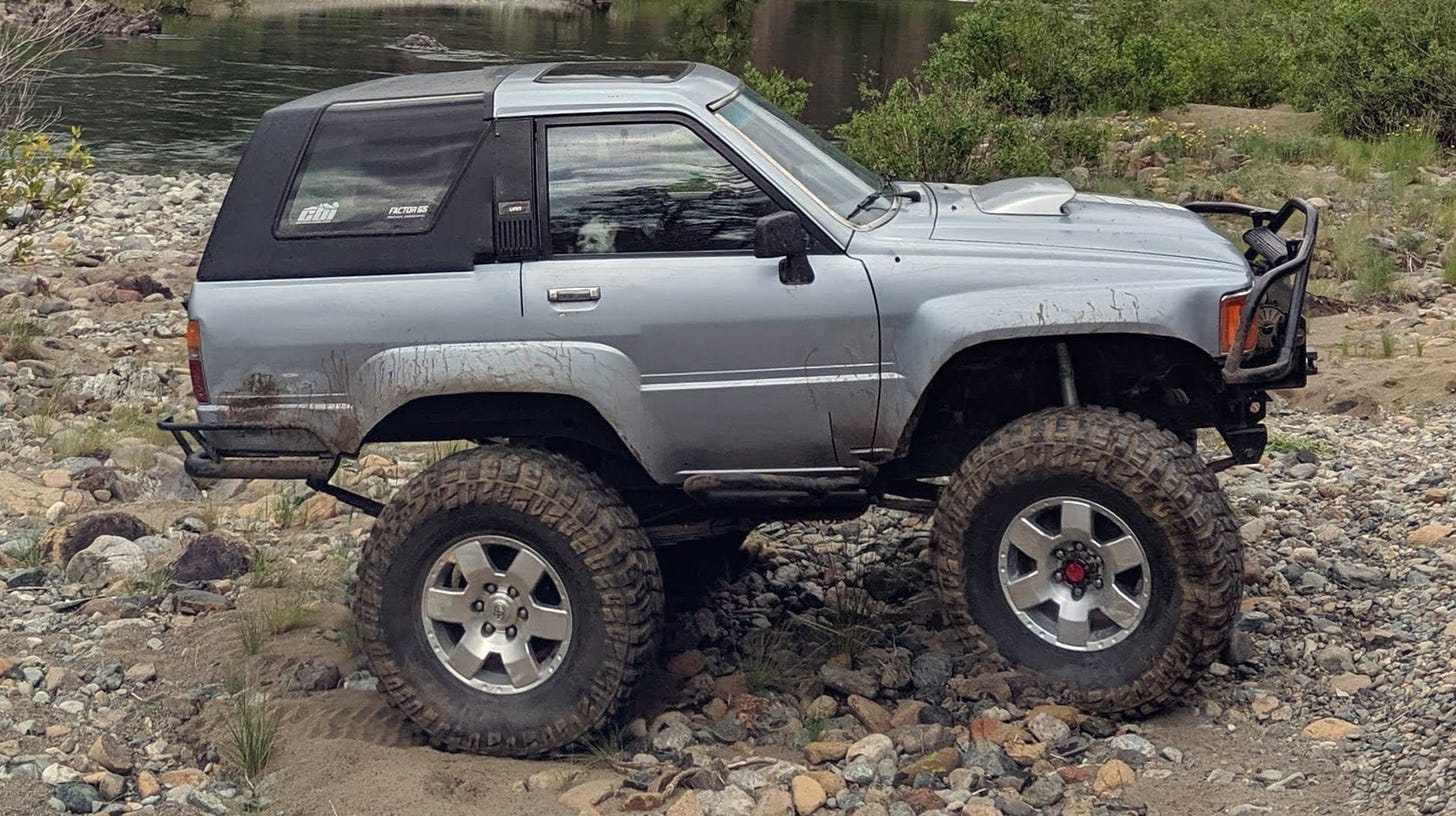 1989 Toyota 4Runner in front of a river. the truck has been digitally altered incorrectly and looks hilariously short.