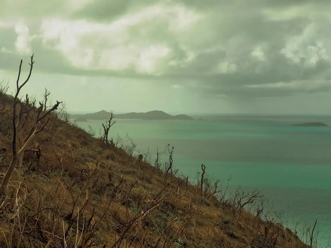 The remains of storm clouds behind a barren hillside