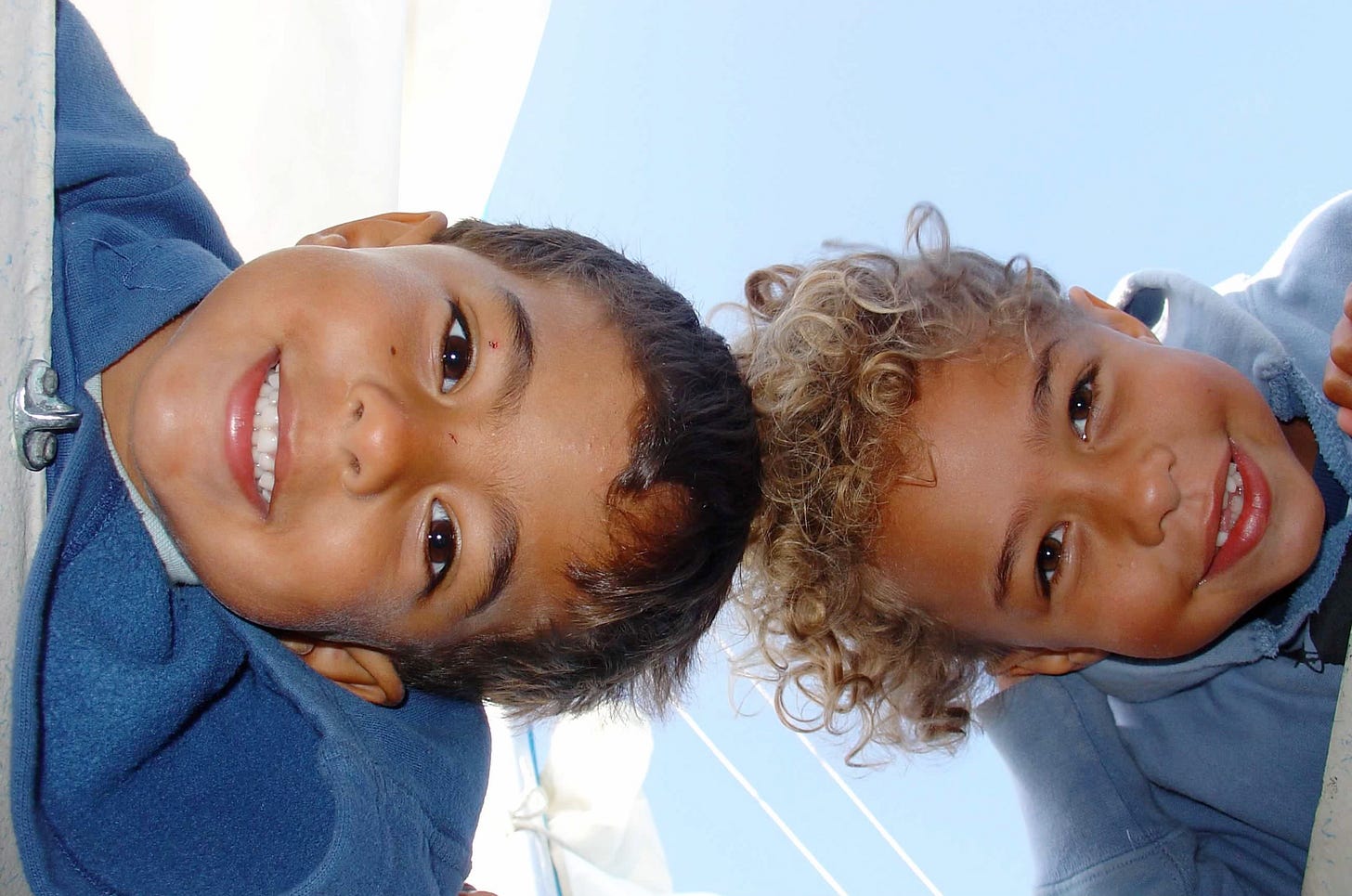 2 biracial kids, about 6 and 8 yrs old, look in through an overhead hatch