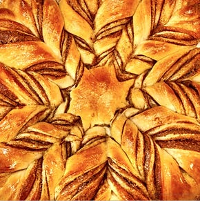 Golden star bread with intricate twists, filled with cinnamon and sugar, showcasing a beautifully symmetrical design.