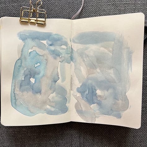 Different pages in a small sketchbook painted with light washes of watercolor in a variety colors