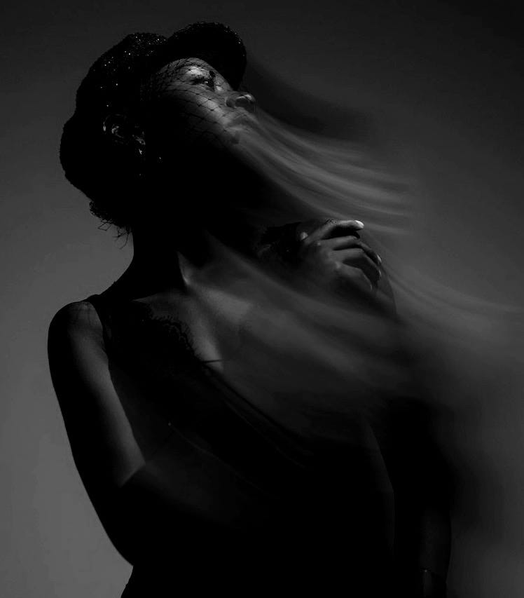 A woman in a black dress with her hair blowing in the wind A woman in a black dress with her hair blowing in the wind